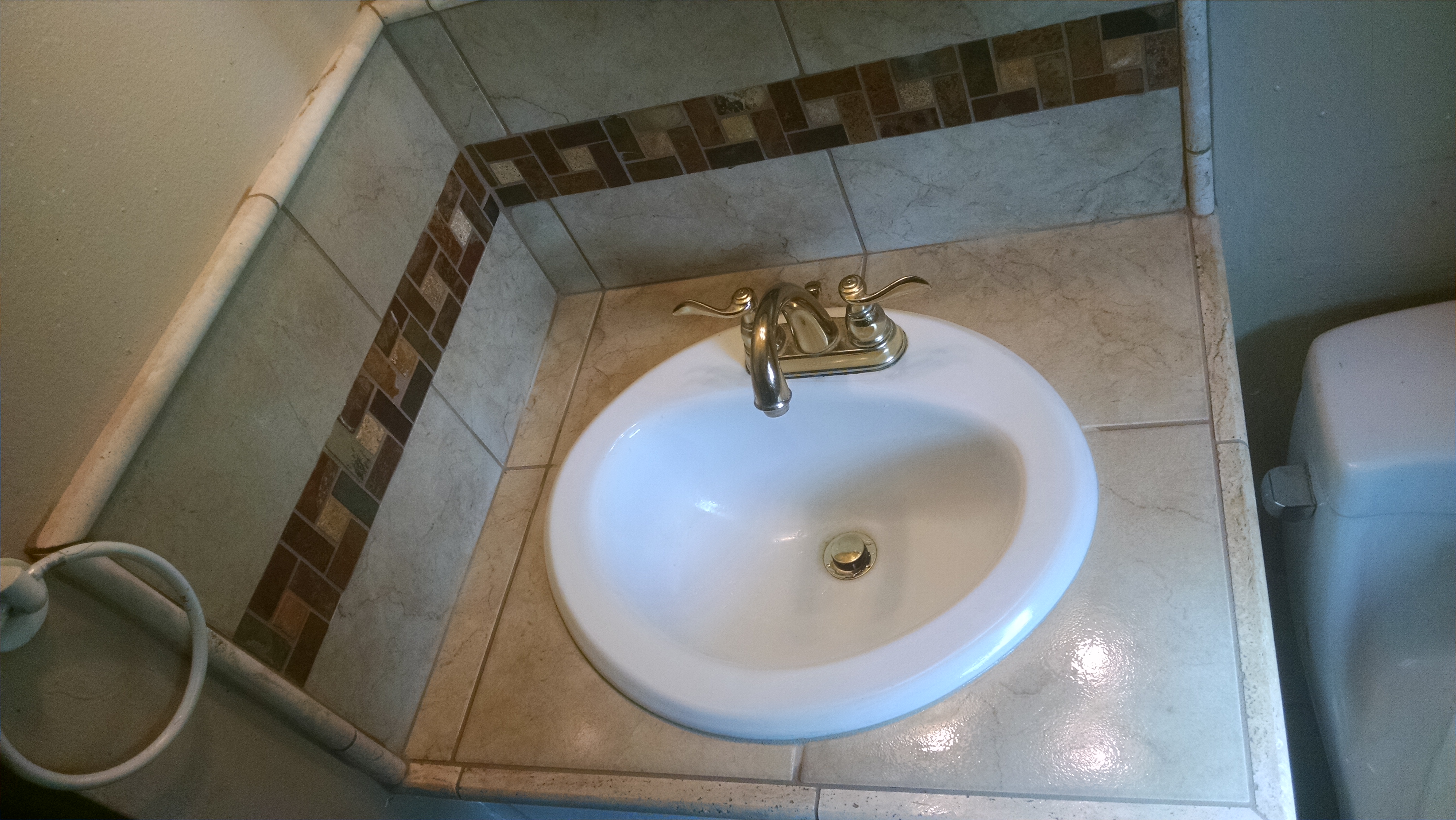 Tiled bathroom counter and backsplash, with design border