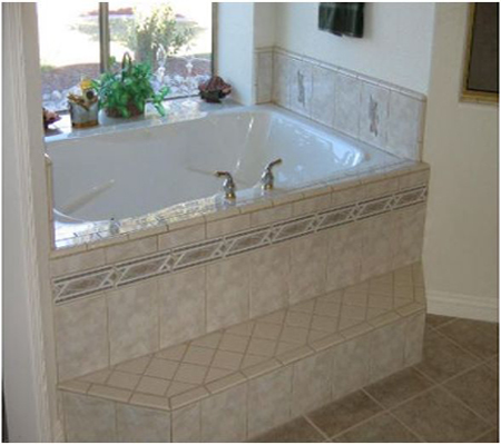 Bathroom with tiled jetted tub surround, step and floor