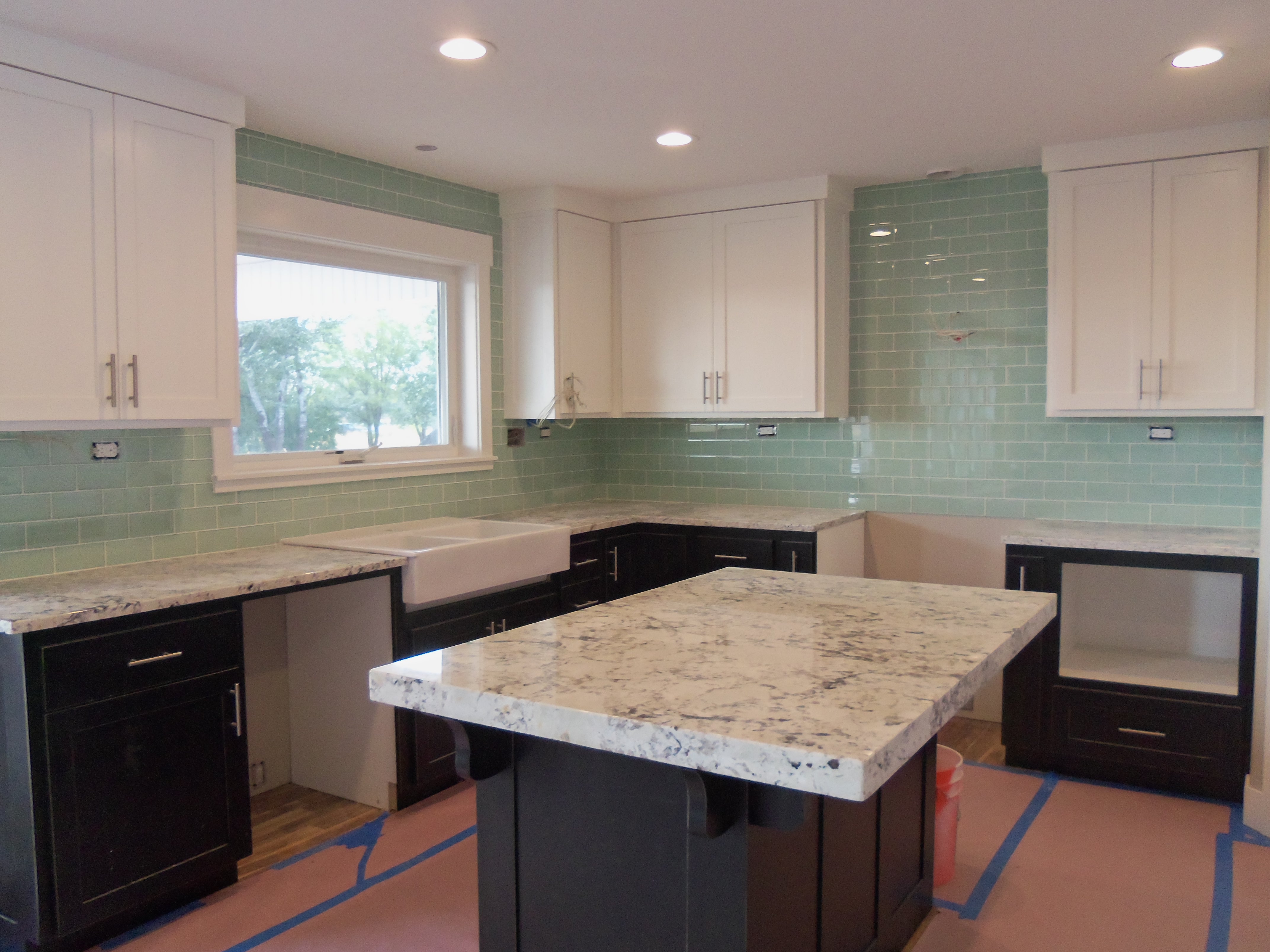 Kitchen backsplash tiled with green glass tiles