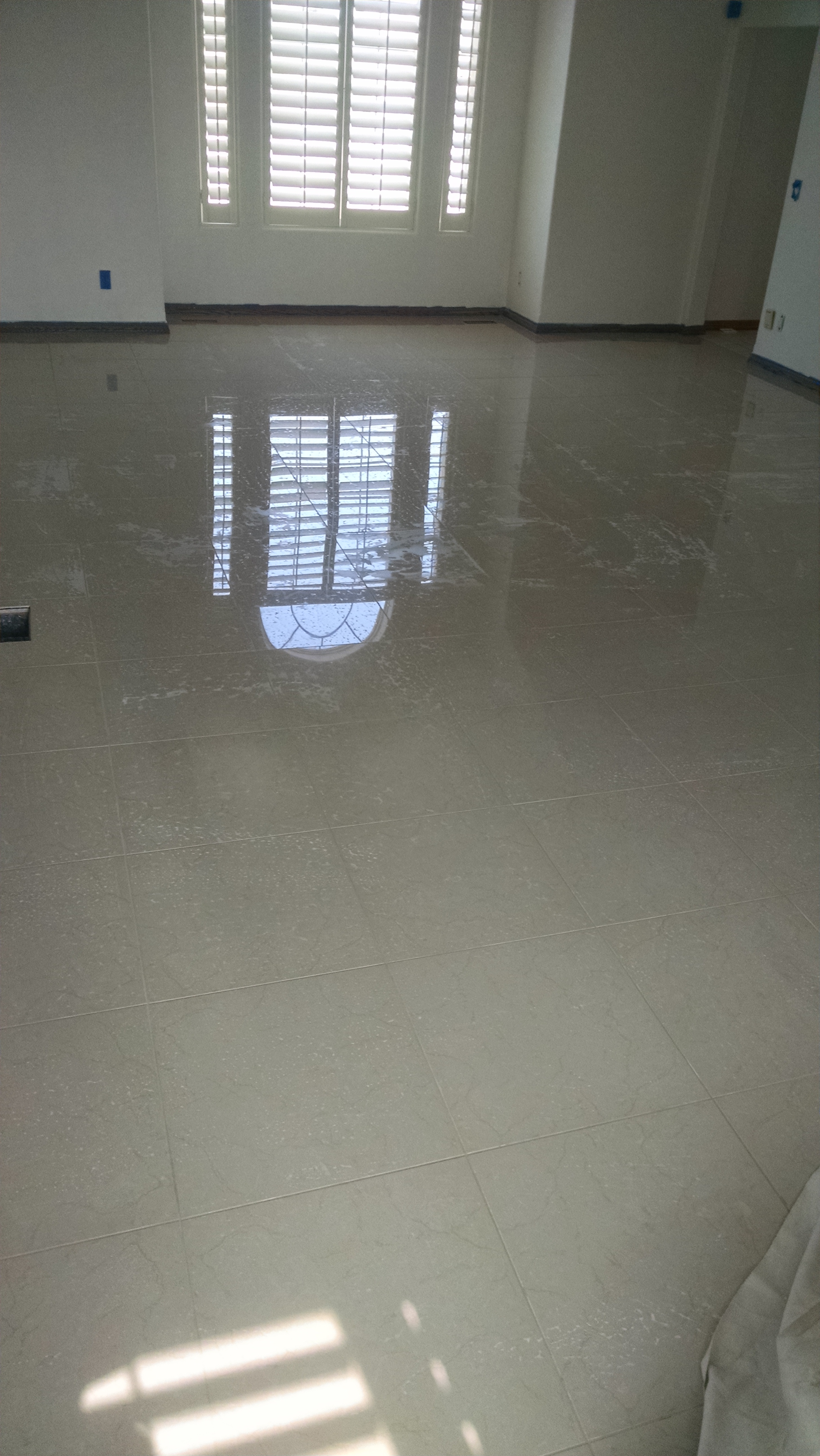 Formal living room floor tiled with mirror finish marble tiles