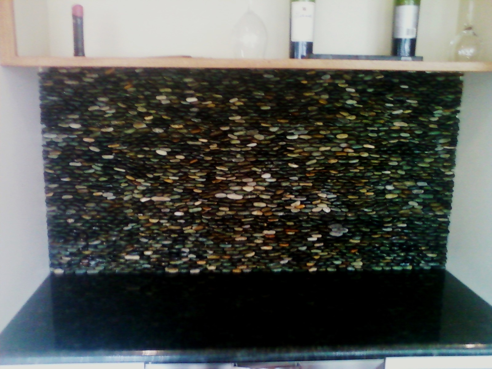 Kitchen backsplash, tiled with small stones and sealed with stone enhancing sealer