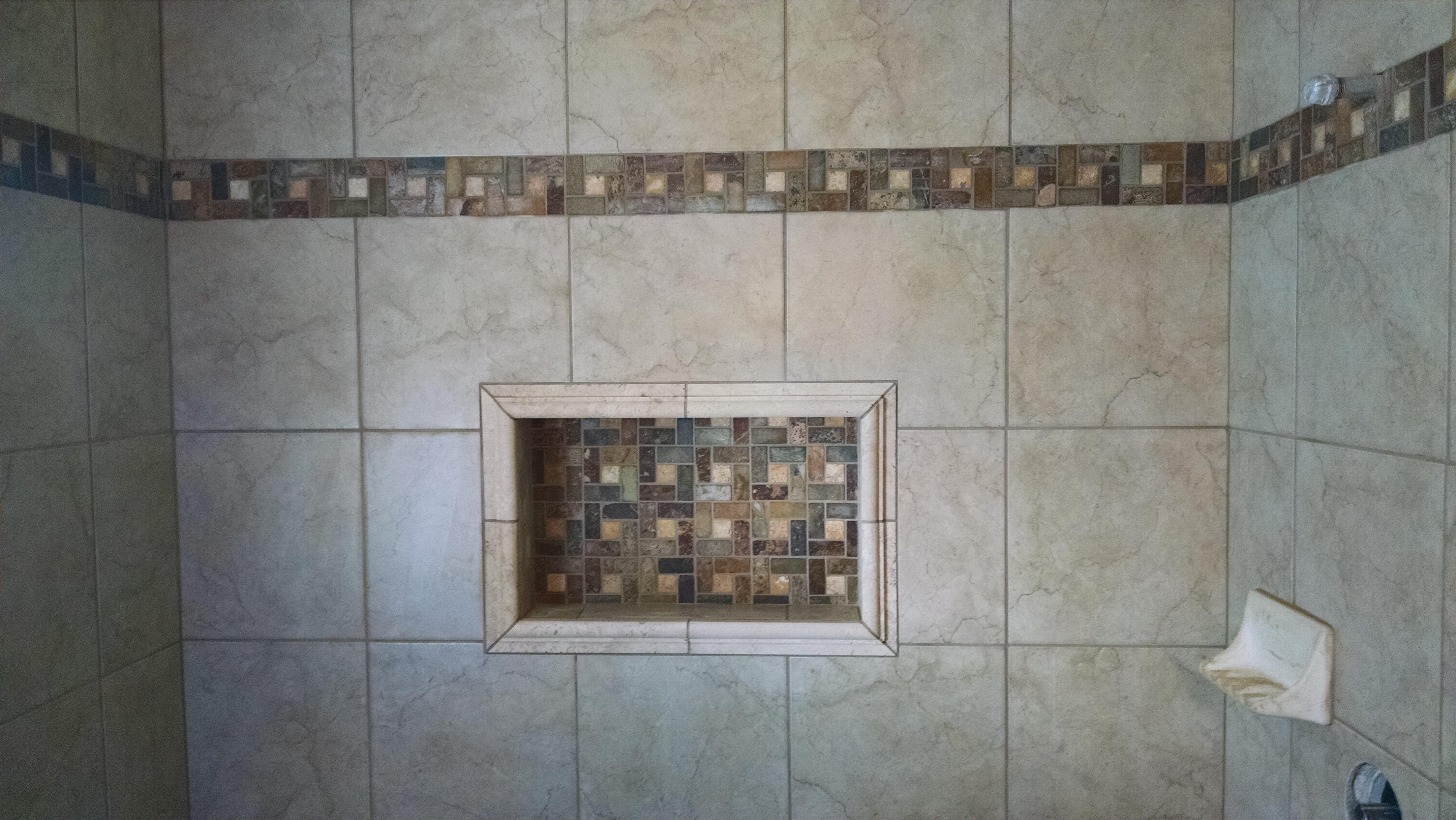 Tiled shower with design border and matching niche